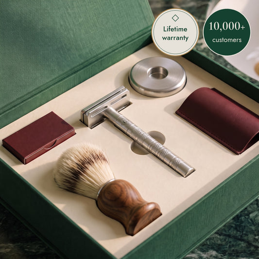 The First Set, open: the razor, its steel stand, the walnut brush, the burgundy leather sleeve and the blade box in the cream tray of the emerald box