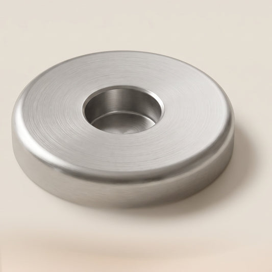 The weighted steel stand: a round puck of brushed steel with a centre recess